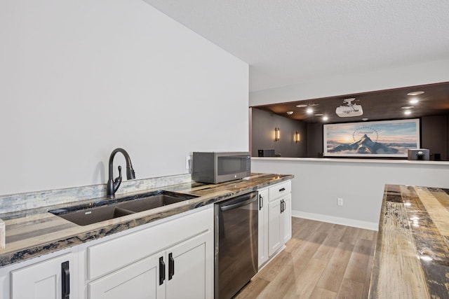 18837 Ogden St NW, Elk River, MN 55330 - kitchen featuring stainless steel appliances, a sink, light wood-style flooring, dark stone countertops, and white cabinetry