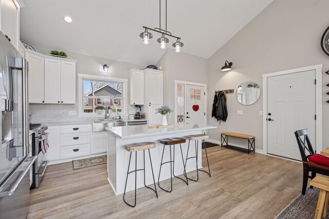 18837 Ogden St NW, Elk River, MN 55330 - kitchen with a sink, stainless steel appliances, high vaulted ceiling, a breakfast bar area, and light countertops