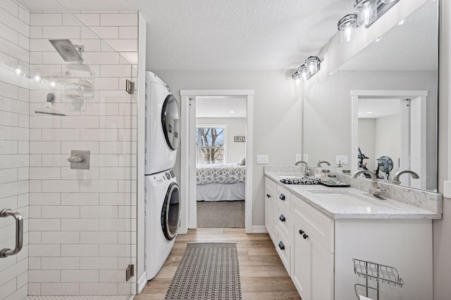18837 Ogden St NW, Elk River, MN 55330 - ensuite bathroom with estacked washer and dryer, wood finished floors, double vanity, and a shower stall