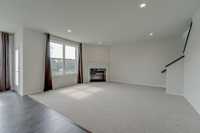 15485 Jersey Ave S, Savage, MN 55378 - unfurnished living room featuring recessed lighting, a fireplace, baseboards, wood finished floors, and stairway