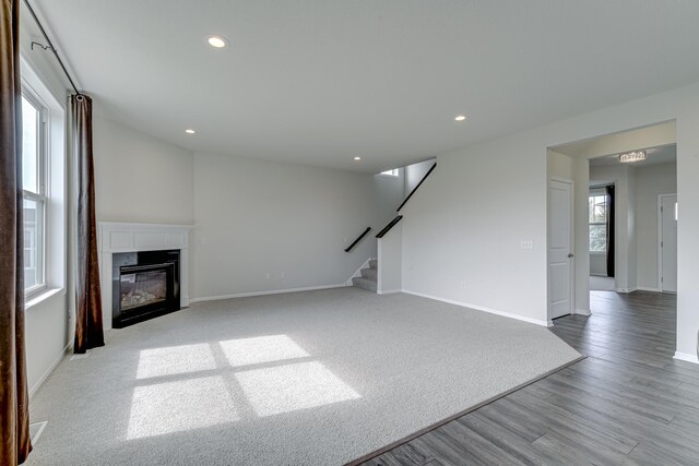 15485 Jersey Ave S, Savage, MN 55378 - unfurnished living room with stairs, baseboards, recessed lighting, a premium fireplace, and wood finished floors