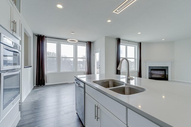 15485 Jersey Ave S, Savage, MN 55378 - kitchen featuring stainless steel appliances, recessed lighting, a glass covered fireplace, light countertops, and white cabinetry