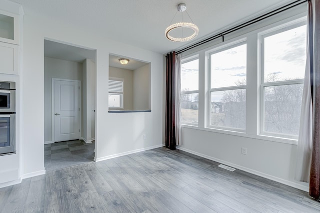 15485 Jersey Ave S, Savage, MN 55378 - unfurnished dining area with wood finished floors and a chandelier