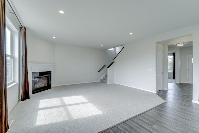 15485 Jersey Ave S, Savage, MN 55378 - unfurnished living room featuring stairway, recessed lighting, a fireplace with flush hearth, and wood finished floors