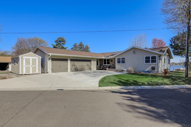ranch-style home featuring driveway, a front yard, an outbuilding, a garage, and a shed