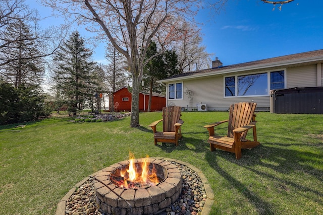 view of yard with a hot tub and an outdoor fire pit