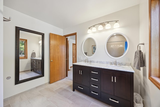 bathroom featuring baseboards, a sink, and double vanity