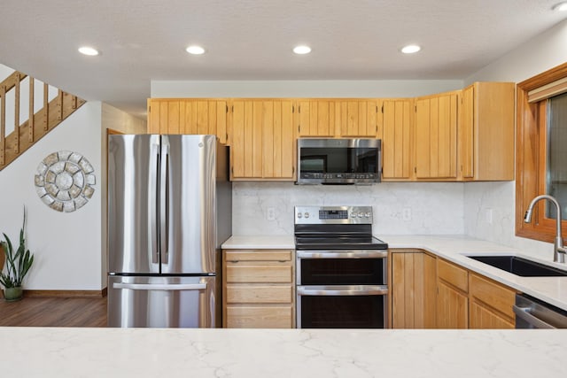 kitchen featuring a sink, dark wood finished floors, recessed lighting, backsplash, and appliances with stainless steel finishes
