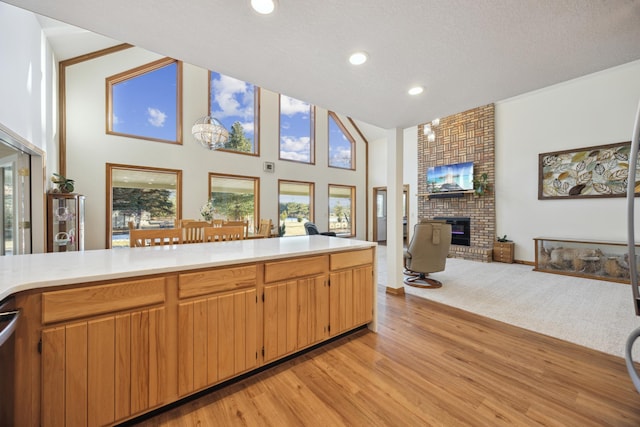 kitchen with recessed lighting, light wood-style flooring, light countertops, and a fireplace