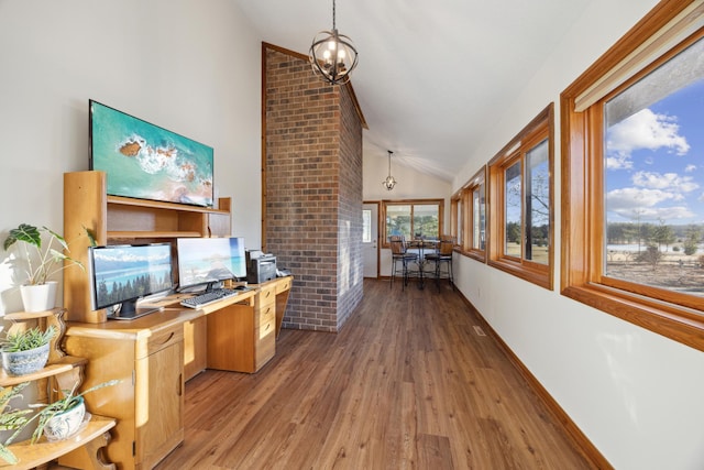 office with vaulted ceiling, an inviting chandelier, and light wood-style flooring