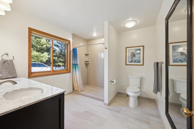 full bath featuring a shower stall, toilet, vanity, and baseboards