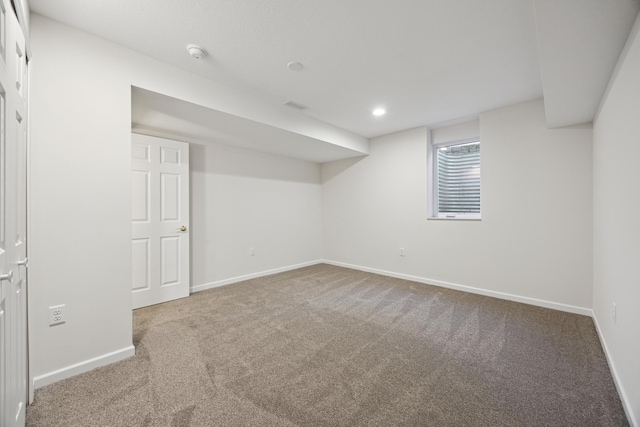 below grade area with carpet floors, visible vents, and baseboards