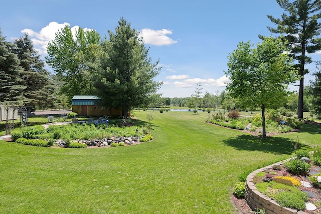 view of yard with a storage unit, an outbuilding, and a water view