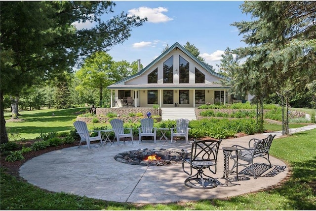back of house with a lawn, a patio, and an outdoor fire pit