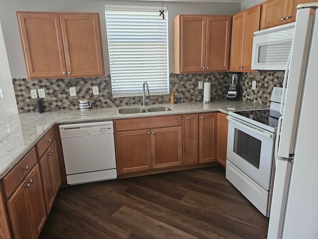 kitchen featuring backsplash, dark wood-style floors, white appliances, and a sink