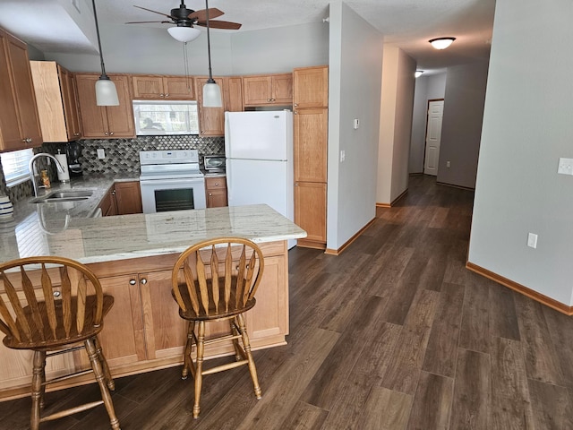 kitchen featuring a peninsula, a ceiling fan, a sink, white appliances, and backsplash