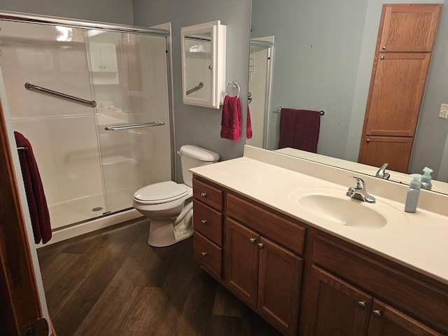 full bathroom featuring vanity, toilet, wood finished floors, and a shower stall