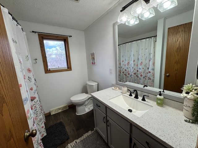 318 Pine Ave S, Sandstone, MN 55072 - full bath featuring a textured ceiling, toilet, visible vents, wood finished floors, and vanity