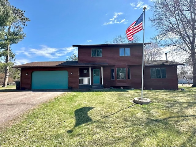 318 Pine Ave S, Sandstone, MN 55072 - view of front of house with aphalt driveway, a front yard, covered porch, and a garage