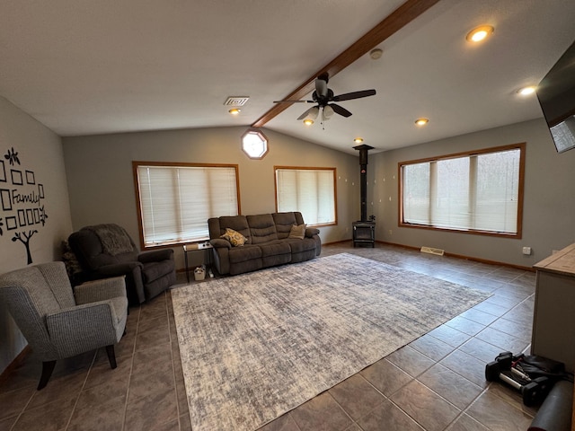 318 Pine Ave S, Sandstone, MN 55072 - living room with dark tile patterned floors, a wood stove, vaulted ceiling with beams, and visible vents