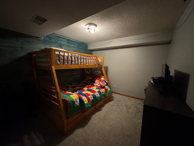 318 Pine Ave S, Sandstone, MN 55072 - carpeted bedroom with baseboards, a textured ceiling, and visible vents