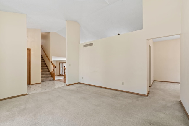 unfurnished living room featuring carpet floors, stairs, baseboards, and high vaulted ceiling