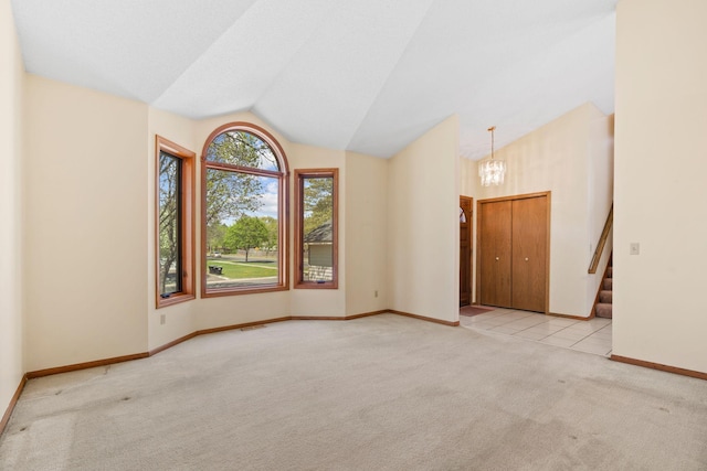 empty room featuring light colored carpet, a chandelier, vaulted ceiling, baseboards, and stairway