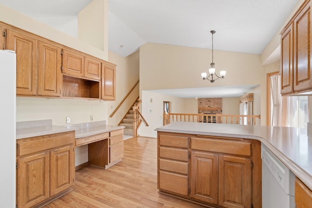 kitchen featuring white appliances, vaulted ceiling, light wood-type flooring, a peninsula, and light countertops