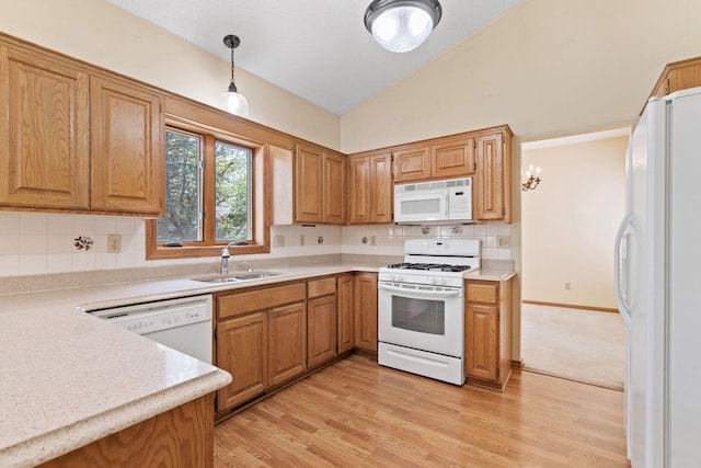 kitchen with white appliances, a sink, light countertops, decorative backsplash, and high vaulted ceiling
