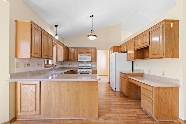 kitchen featuring white appliances, a peninsula, vaulted ceiling, light wood-style flooring, and a sink