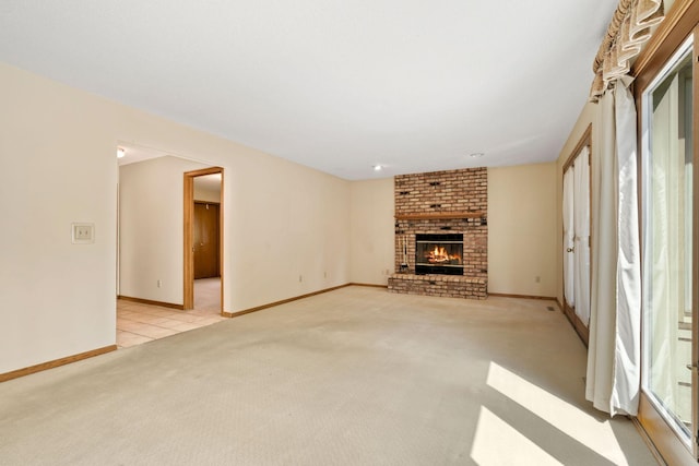 unfurnished living room featuring light colored carpet, a fireplace, and baseboards