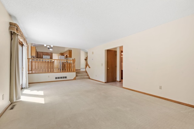 unfurnished living room featuring light carpet and baseboards