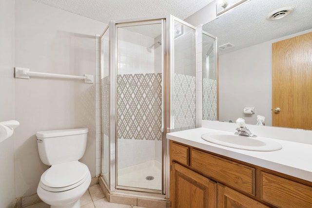 bathroom featuring a textured ceiling, toilet, a shower stall, vanity, and tile patterned flooring