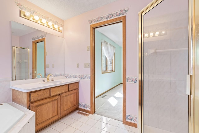 bathroom featuring a stall shower, tile patterned flooring, a bath, and vanity