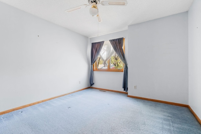 carpeted empty room featuring ceiling fan, baseboards, and a textured ceiling
