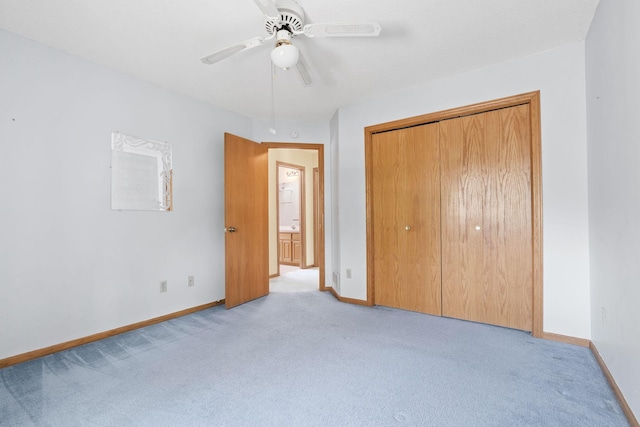 unfurnished bedroom with light carpet, baseboards, a closet, and a ceiling fan