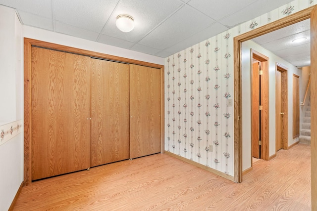unfurnished bedroom featuring light wood finished floors, a closet, and wallpapered walls
