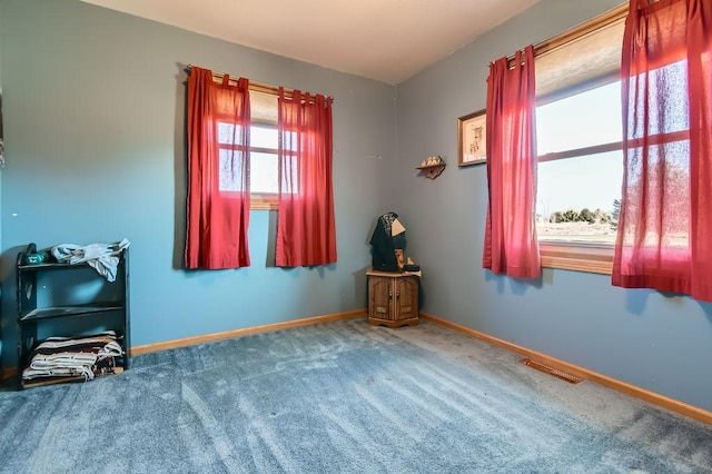 empty room featuring baseboards, visible vents, and carpet flooring