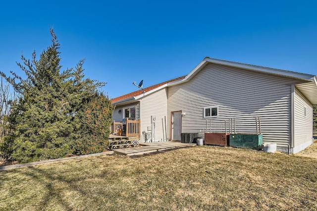back of house featuring a wooden deck and a lawn