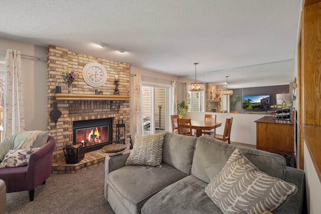 carpeted living area with a brick fireplace, a chandelier, and a textured ceiling