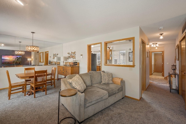 carpeted living area with baseboards and a textured ceiling