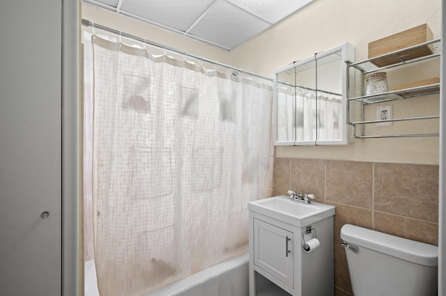 full bathroom with vanity, shower / bath combo, toilet, and tile walls