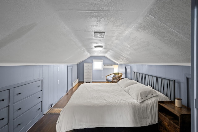 bedroom featuring a textured ceiling, dark wood finished floors, lofted ceiling, and baseboard heating