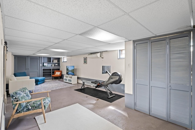 workout room featuring baseboards, a drop ceiling, electric panel, and a wall mounted air conditioner