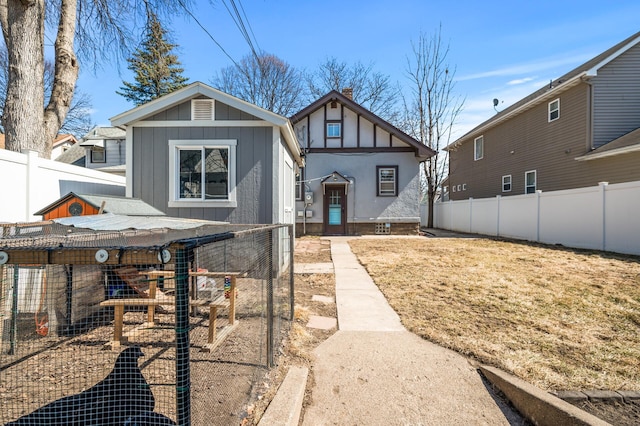 view of front of home with board and batten siding, exterior structure, and fence