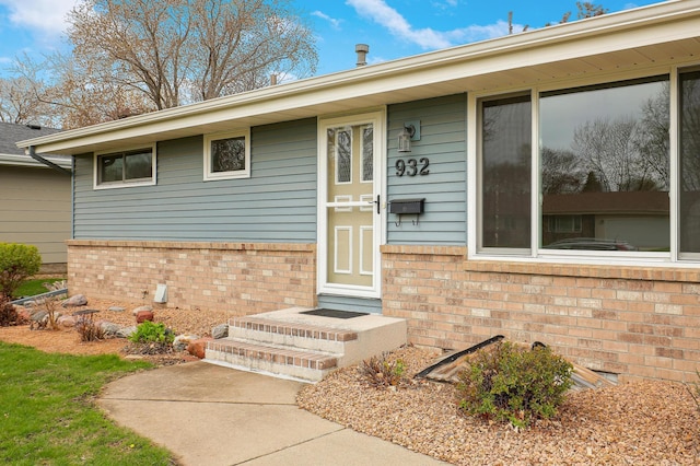 view of exterior entry with brick siding