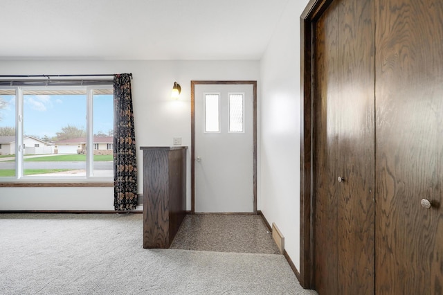 carpeted entryway featuring baseboards