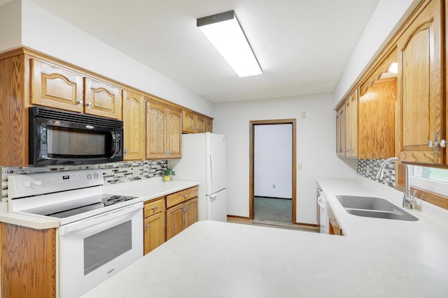 kitchen with a sink, light countertops, decorative backsplash, and white appliances