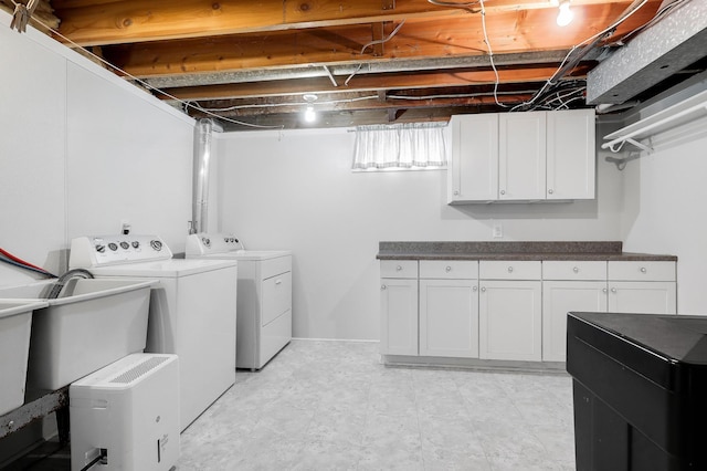 laundry area with washing machine and clothes dryer and cabinet space