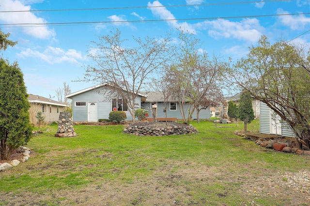 rear view of property featuring a yard and an outdoor structure